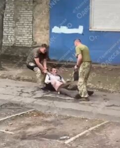 Shocking Scene in Ukraine: TRC Workers Drag Young Man with Backpack Across Pavement Before He Escapes